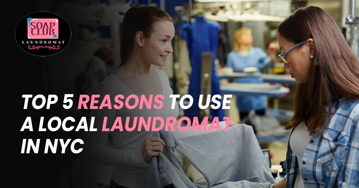 Two women at a laundromat discussing freshly cleaned clothes with Soap Club Laundromat logo displayed.